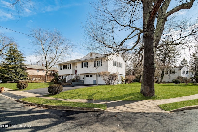 raised ranch with a garage, aphalt driveway, and a front yard