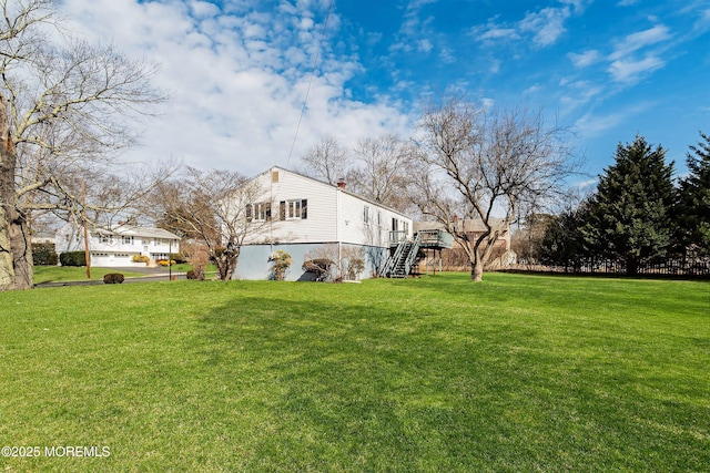 view of side of property featuring a yard and stairs