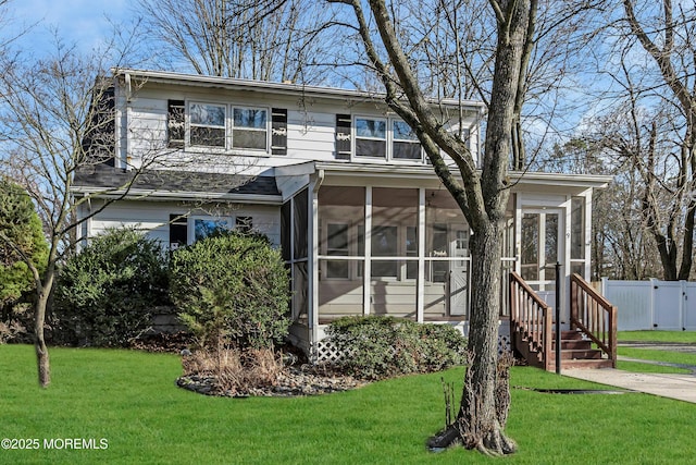 view of front of property featuring a front lawn and a sunroom