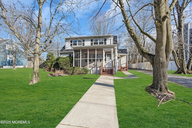 view of front facade featuring a sunroom and a front yard