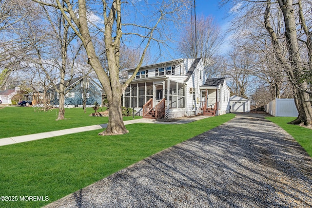 view of front facade featuring a garage, a sunroom, and a front yard