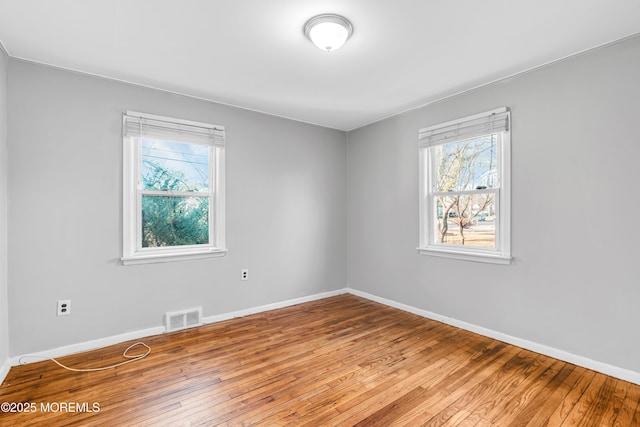 empty room featuring hardwood / wood-style flooring and a healthy amount of sunlight