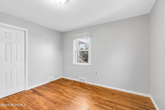 empty room with hardwood / wood-style floors