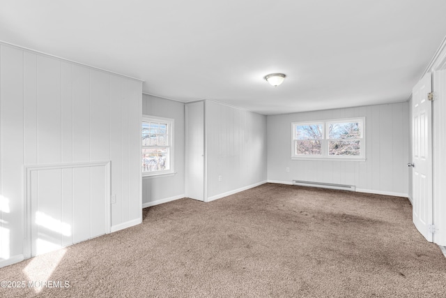 carpeted empty room featuring baseboard heating