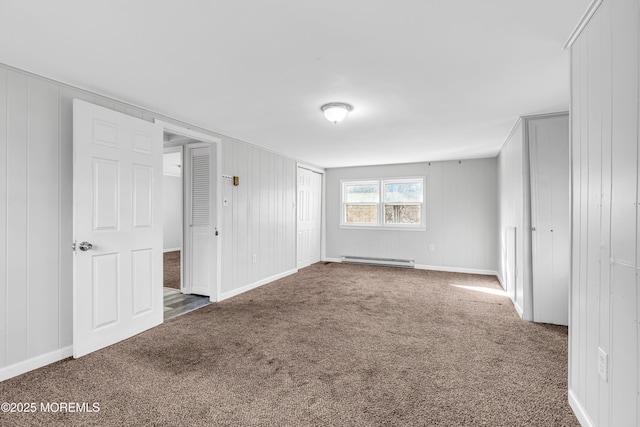 empty room featuring dark carpet and baseboard heating