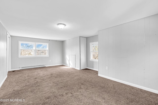 carpeted spare room featuring a baseboard radiator and a healthy amount of sunlight