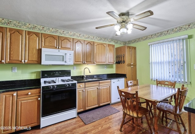 kitchen featuring sink, white appliances, ceiling fan, a textured ceiling, and light wood-type flooring