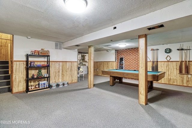 recreation room with billiards, a textured ceiling, and wood walls