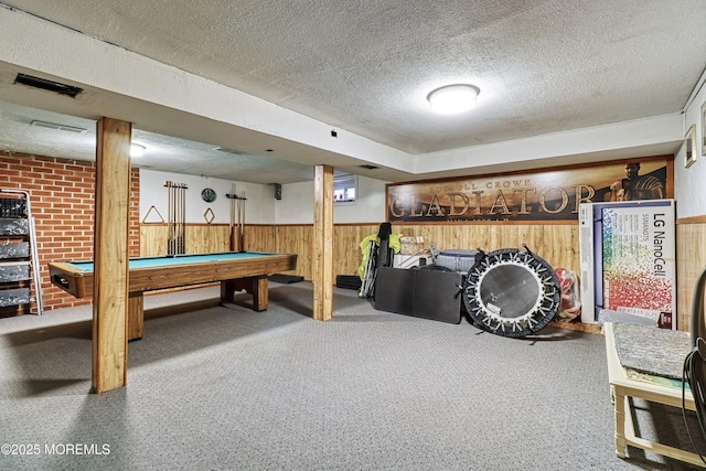 rec room with pool table, wooden walls, and a textured ceiling