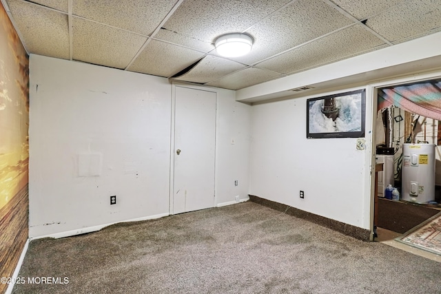 basement featuring water heater, carpet, a paneled ceiling, and washer / clothes dryer