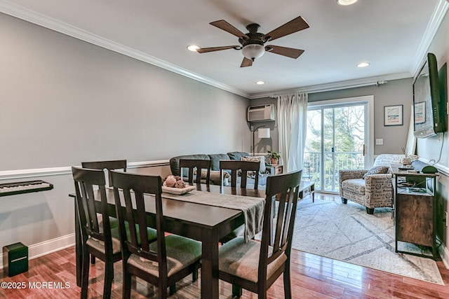 dining space with hardwood / wood-style flooring, ornamental molding, and an AC wall unit