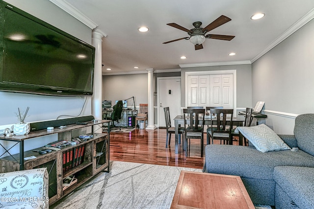 living room featuring hardwood / wood-style floors, crown molding, decorative columns, and ceiling fan