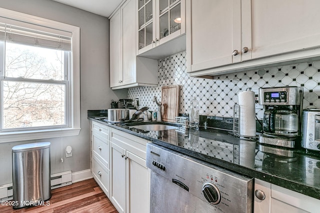 kitchen with a healthy amount of sunlight, white cabinets, and backsplash