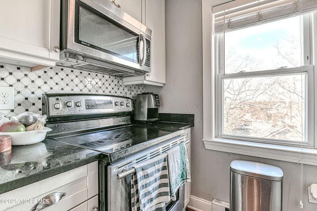 kitchen with tasteful backsplash, appliances with stainless steel finishes, and a baseboard heating unit