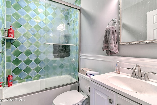 full bathroom with vanity, enclosed tub / shower combo, and toilet