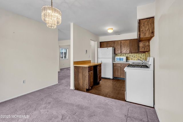 kitchen with backsplash, hanging light fixtures, dark colored carpet, a notable chandelier, and white appliances