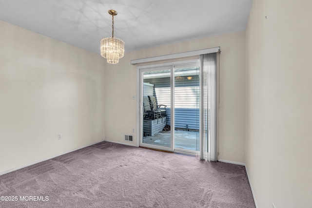 carpeted empty room with a chandelier