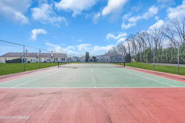 view of sport court with basketball hoop and a lawn