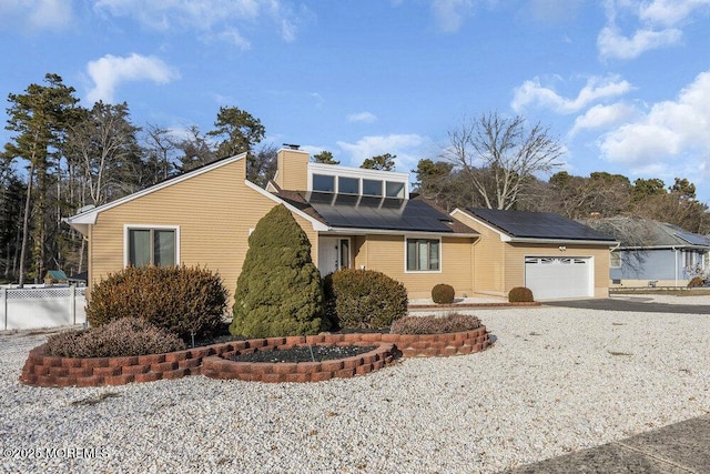 view of property featuring a garage and solar panels