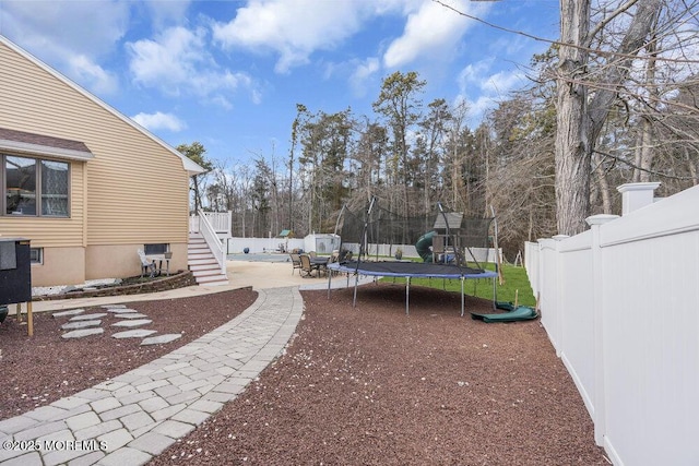 view of yard with a trampoline, a patio, and a playground