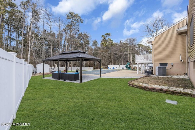 view of yard featuring cooling unit, an outdoor living space, a gazebo, a covered pool, and a patio area