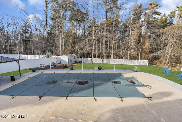 view of swimming pool featuring a yard and a storage unit