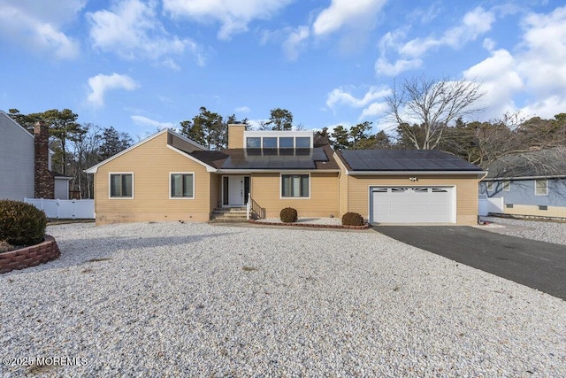 view of property featuring a garage and solar panels