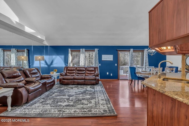 living room with vaulted ceiling, sink, a notable chandelier, and dark hardwood / wood-style floors