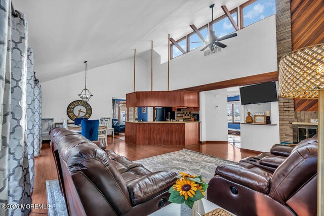 living room with wood-type flooring, a brick fireplace, and high vaulted ceiling