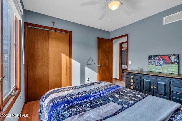 bedroom featuring hardwood / wood-style flooring, ceiling fan, and a closet