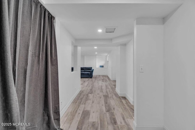 corridor with light hardwood / wood-style floors