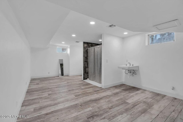 spare room featuring sink and light hardwood / wood-style floors