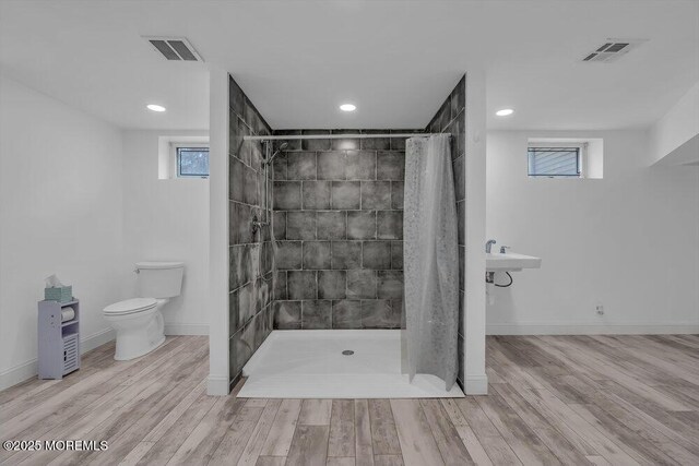 bathroom featuring a healthy amount of sunlight, hardwood / wood-style floors, toilet, and a shower with shower curtain