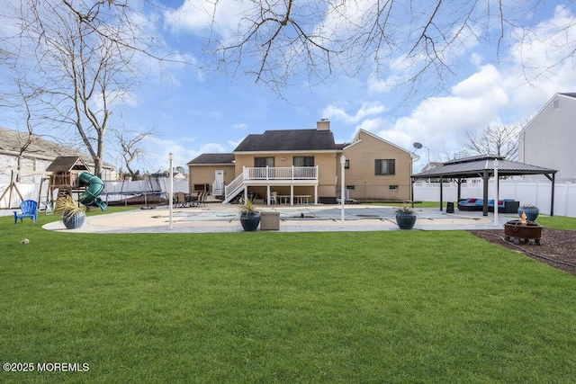 back of property with a gazebo, a swimming pool, a patio, and a playground