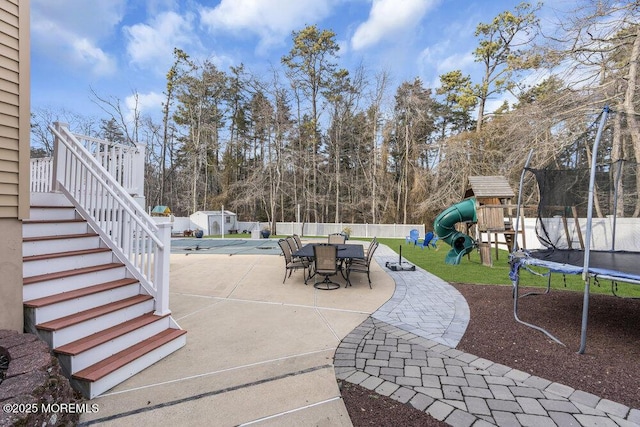 view of patio featuring a trampoline and a playground