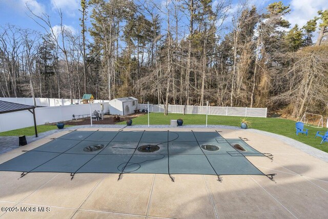 view of swimming pool with a shed and a yard