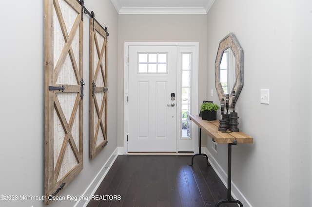 entrance foyer featuring a barn door, ornamental molding, and dark hardwood / wood-style floors