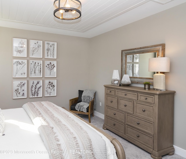 carpeted bedroom with an inviting chandelier