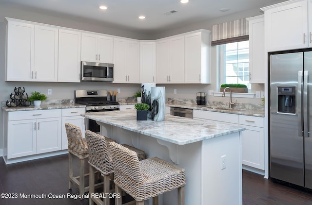 kitchen featuring stainless steel appliances, white cabinetry, and sink