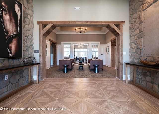 unfurnished living room featuring light parquet floors, a towering ceiling, and a chandelier