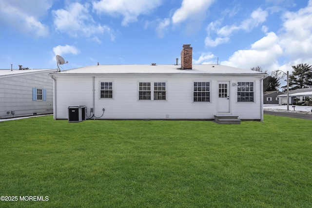 back of property featuring a lawn and central air condition unit