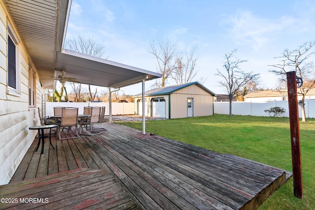 deck with a garage, an outbuilding, and a yard