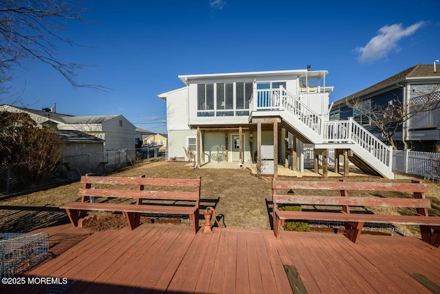 back of property featuring a patio, a sunroom, and a deck