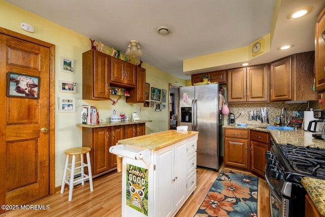 kitchen featuring light stone countertops, sink, stainless steel appliances, and light hardwood / wood-style floors