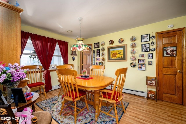 dining room with baseboard heating and light hardwood / wood-style flooring