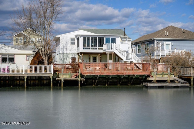 rear view of house featuring a water view and a sunroom