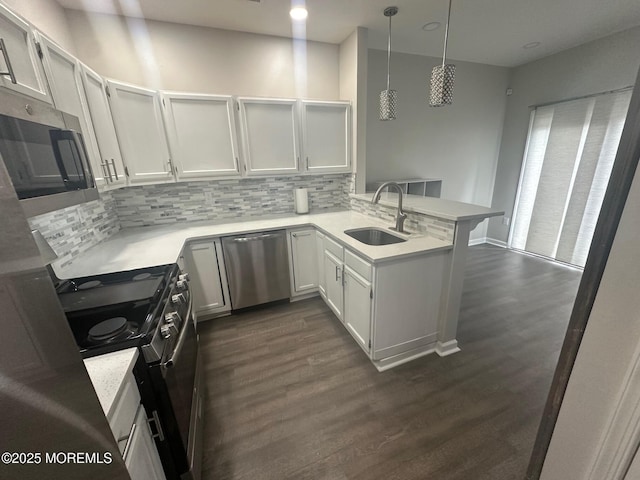 kitchen with hanging light fixtures, white cabinetry, sink, and kitchen peninsula