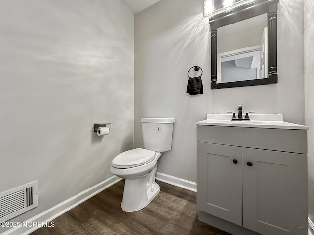 bathroom with hardwood / wood-style flooring, vanity, and toilet