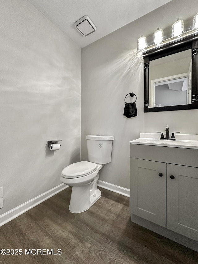 bathroom with wood-type flooring, vanity, and toilet