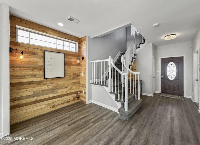 entryway featuring dark hardwood / wood-style flooring and wood walls